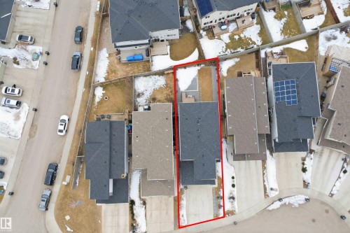 Aerial view of the property, featuring a paved driveway, a backyard with a patio area, and a dark-toned roof - 8424 Cushing Court, Edmonton, AB - 