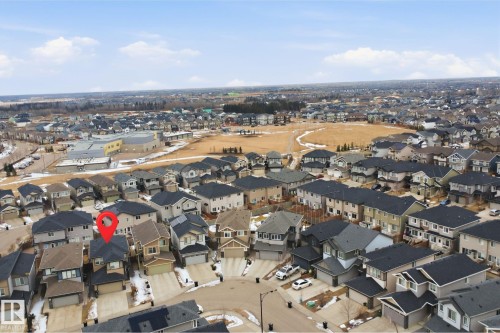 The property is situated within a residential neighborhood featuring various house styles and a large, open field area - 8424 Cushing Court, Edmonton, AB - Outdoor With View