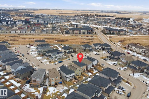 Aerial view of the property and its surrounding neighborhood, featuring residential homes with dark roofs and a mixture of bare and snow-covered ground - 8424 Cushing Court, Edmonton, AB - Outdoor With View