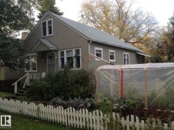 The property features a stucco exterior, a sloped roof, and a front porch with white railings - 