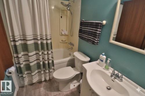 Bathroom featuring a bathtub with a shower, a toilet, and a vanity with a sink and faucet - 11 Willow Park Estates, Leduc, AB - Indoor Photo Showing Bathroom