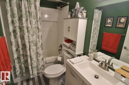This bathroom features a vanity with a sink and a silver-toned faucet, a mirror, and a bathtub with a shower - 11 Willow Park Estates, Leduc, AB - Indoor Photo Showing Bathroom