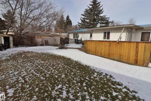 The property features a spacious rear yard with a lawn, a wooden deck with a privacy fence, and a storage shed - 11 Willow Park Estates, Leduc, AB - Outdoor