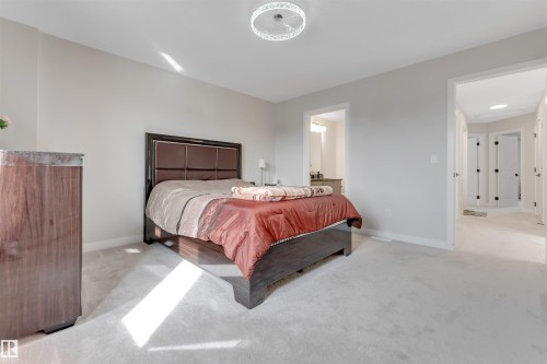 This room features light-colored carpeting, neutral painted walls, and a modern ceiling light fixture - 6404 27 Avenue, Edmonton, AB - Indoor Photo Showing Bedroom
