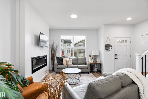 The living room features a modern electric fireplace, recessed lighting, and a white paneled accent wall - 20 Hemingway Crescent, Spruce Grove, AB - Indoor Photo Showing Living Room With Fireplace