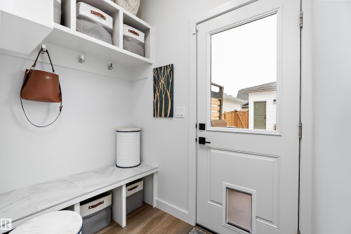 Entryway featuring a white door with a window, built-in shelving, and a bench with a marbled top - 20 Hemingway Crescent, Spruce Grove, AB - Indoor Photo Showing Other Room
