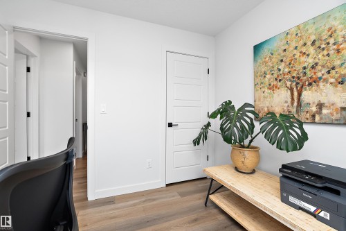 This room features light wood-style flooring, white walls, and a five-panel interior door with black hardware - 20 Hemingway Crescent, Spruce Grove, AB - Indoor