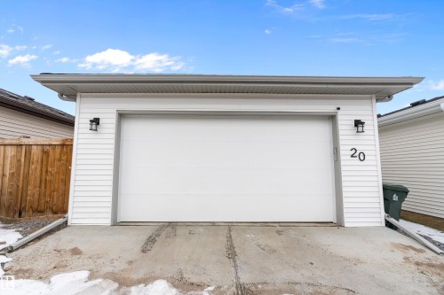 Detached garage with white siding, a white garage door, and exterior lighting fixtures - 20 Hemingway Crescent, Spruce Grove, AB - Outdoor With Exterior