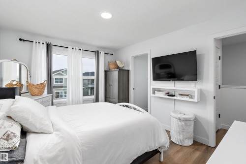 This inviting interior features light-colored walls and wood-look flooring - 20 Hemingway Crescent, Spruce Grove, AB - Indoor Photo Showing Bedroom