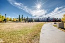 Community green space featuring a paved walkway, street lights, and park benches - 63 3625 144 Avenue Nw, Edmonton, AB  - Outdoor With View 