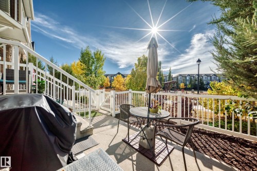 Outdoor patio with a white railing and stairs, featuring a concrete surface - 63 3625 144 Avenue Nw, Edmonton, AB - Outdoor With Exterior