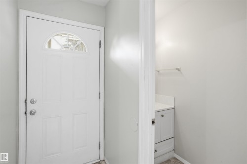 Entryway featuring a white door with an arched window detail and natural light - 18297 74 Avenue, Edmonton, AB - Indoor Photo Showing Other Room
