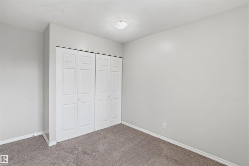 This room features neutral-toned walls, a textured ceiling, and gray carpet - 18297 74 Avenue, Edmonton, AB - Indoor Photo Showing Other Room