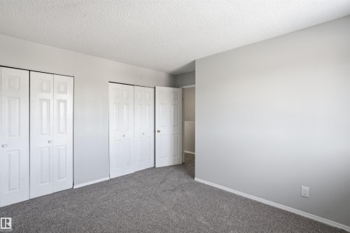 This room features soft gray carpeting and light gray walls - 18297 74 Avenue, Edmonton, AB - Indoor