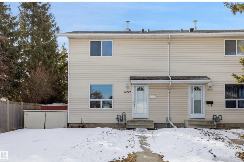 The property features a light-colored exterior with white trim windows and doors - 18297 74 Avenue, Edmonton, AB - Outdoor