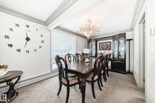 This dining area features a decorative ceiling, a large window with horizontal blinds, and carpeted flooring - 12131 101 Street Nw, Edmonton, AB - Indoor Photo Showing Dining Room