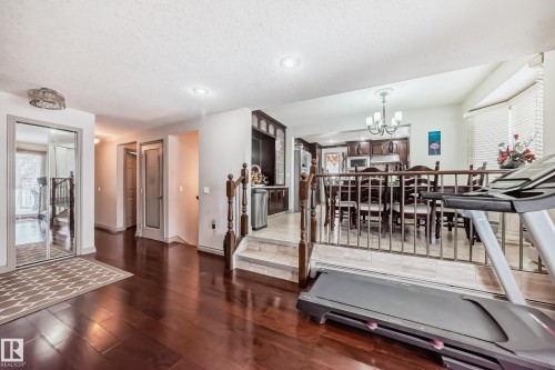 The property features hardwood flooring in the main area and a kitchen with dark wood cabinetry and a dining space - 12131 101 Street Nw, Edmonton, AB - Indoor Photo Showing Other Room