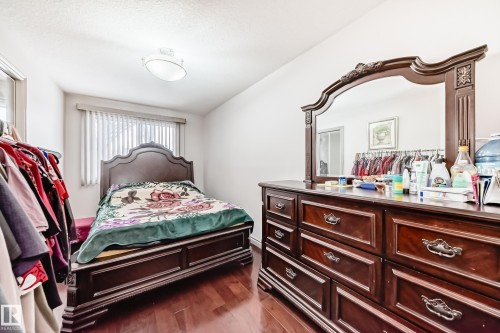 This bedroom features hardwood floors, a window with blinds, and a ceiling light fixture - 12131 101 Street Nw, Edmonton, AB - Indoor Photo Showing Bedroom