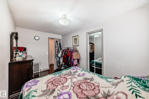 This room features white walls, a ceiling light fixture, and a mirrored closet door - 12131 101 Street Nw, Edmonton, AB - Indoor Photo Showing Bedroom
