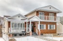 Exterior view of the property featuring a brick and stucco facade, a covered front porch, and a second-story balcony with white railings - 12131 101 Street Nw, Edmonton, AB  - Outdoor With Facade 