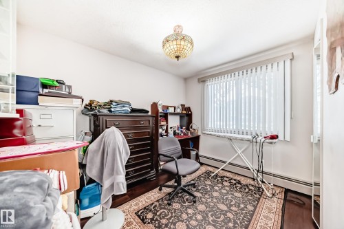 The room features white walls, dark flooring, and a window with vertical blinds - 12131 101 Street Nw, Edmonton, AB - Indoor Photo Showing Office