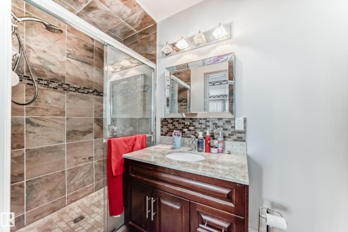 This bathroom features a shower with tiled walls and a glass enclosure - 12131 101 Street Nw, Edmonton, AB - Indoor Photo Showing Bathroom