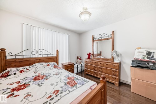 This room features wood flooring, vertical blinds on the window, and a ceiling light fixture - 12131 101 Street Nw, Edmonton, AB - Indoor Photo Showing Bedroom