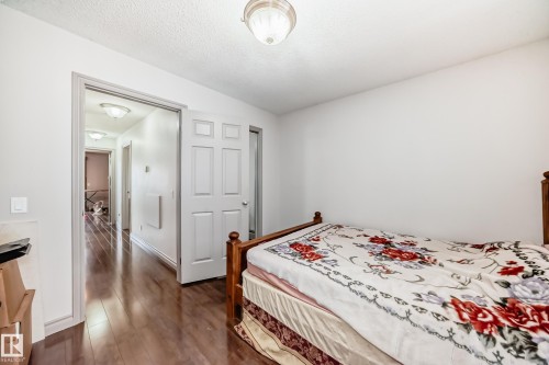 This room features light-colored walls and wood-look flooring - 12131 101 Street Nw, Edmonton, AB - Indoor Photo Showing Bedroom