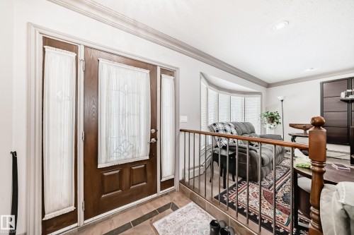 The property features a wood front door with decorative glass panels and side lights - 12131 101 Street Nw, Edmonton, AB - Indoor Photo Showing Other Room