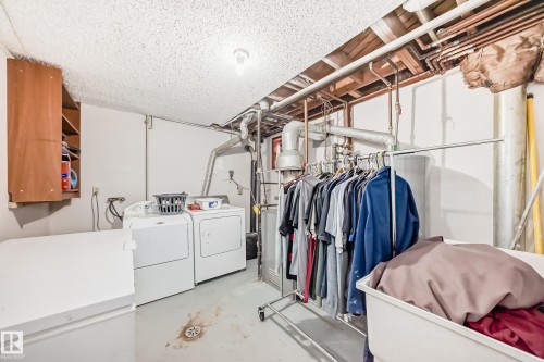 Laundry area featuring a washer, dryer, and overhead exposed piping - 12131 101 Street Nw, Edmonton, AB - Indoor Photo Showing Laundry Room