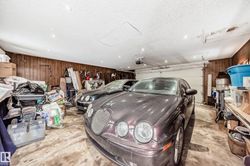 The property features a garage with wood paneling, a garage door, and recessed lighting - 12131 101 Street Nw, Edmonton, AB - Indoor Photo Showing Garage