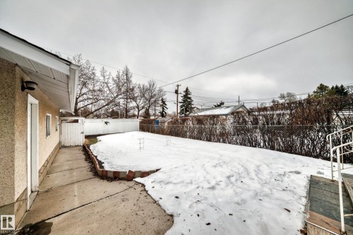 The property features a spacious yard with a paved walkway, a white fence, and a chain-link fence - 12131 101 Street Nw, Edmonton, AB - Outdoor