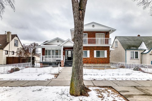The property features a brick exterior with white trim and a front porch - 12131 101 Street Nw, Edmonton, AB - Outdoor With Facade
