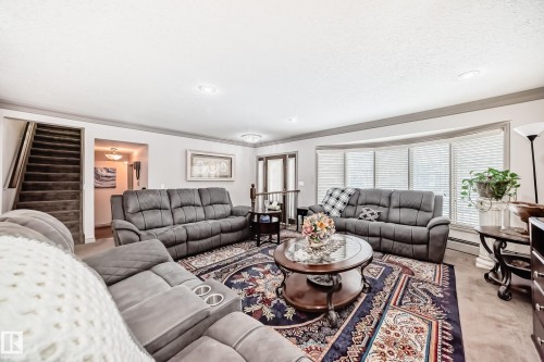 Living area featuring a bay window with blinds, recessed lighting, and carpeted flooring - 12131 101 Street Nw, Edmonton, AB - Indoor Photo Showing Living Room
