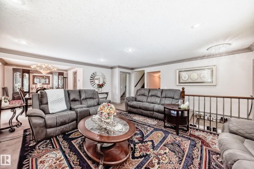 Spacious living area featuring a decorative area rug, recessed lighting, and a chandelier - 12131 101 Street Nw, Edmonton, AB - Indoor Photo Showing Living Room
