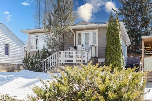 The property features a gray exterior with white trim and a front porch with white railings - 10643 66 Avenue, Edmonton, AB - Outdoor