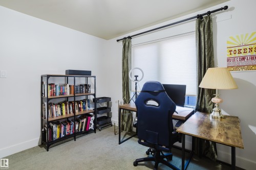 This adaptable room features a window with blinds and drapes, a bookshelf, and carpeted flooring - 10643 66 Avenue, Edmonton, AB - Indoor Photo Showing Office
