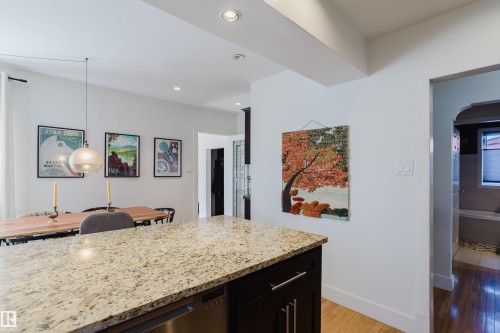 The property features an open-concept living area with hardwood flooring, recessed lighting, and a kitchen island with a granite countertop - 10643 66 Avenue, Edmonton, AB - Indoor