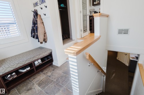 Entryway featuring tiled flooring, a window with horizontal blinds, and a built-in bench with open shelving - 10643 66 Avenue, Edmonton, AB - Indoor Photo Showing Other Room