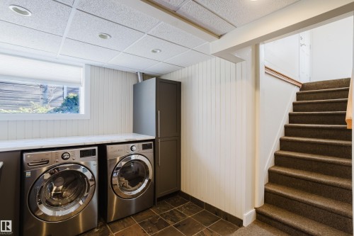 The laundry area features a window, a built-in countertop, and an adjacent storage cabinet - 10643 66 Avenue, Edmonton, AB - Indoor Photo Showing Laundry Room