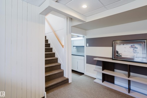 This area features a carpeted staircase with a light wood handrail, a white paneled wall, and recessed lighting - 10643 66 Avenue, Edmonton, AB - Indoor Photo Showing Other Room