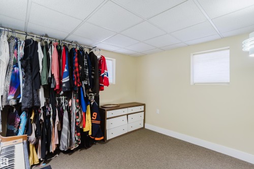 This versatile room features carpeted flooring, a drop ceiling, and a window with blinds - 10643 66 Avenue, Edmonton, AB - Indoor