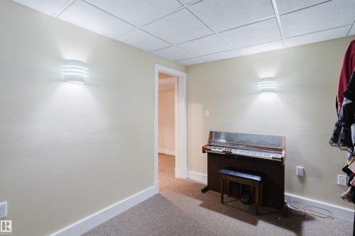 This room features wall-mounted light fixtures, a drop ceiling, and light-colored walls - 10643 66 Avenue, Edmonton, AB - Indoor Photo Showing Other Room