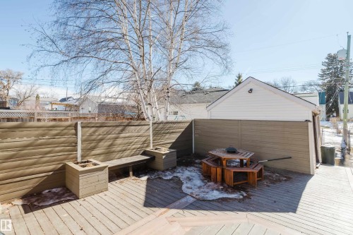 The property features a wooden deck with a privacy fence, built-in planters, and a wooden bench - 10643 66 Avenue, Edmonton, AB - Outdoor With Deck Patio Veranda
