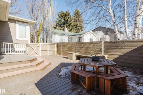 The property features a spacious deck with steps, a fenced yard, and a paved patio area - 10643 66 Avenue, Edmonton, AB - Outdoor With Deck Patio Veranda