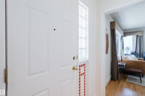 Entryway featuring a paneled door with decorative glass inserts and a view into a room with hardwood floors - 10643 66 Avenue, Edmonton, AB - Indoor Photo Showing Other Room