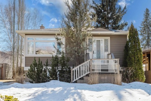 This property features a welcoming front exterior with a covered porch and white railing, complete with steps leading to the entrance - 10643 66 Avenue, Edmonton, AB - Outdoor