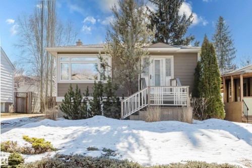 The property features an exterior with gray siding, a white front door, and a white deck with railings - 10643 66 Avenue, Edmonton, AB - Outdoor