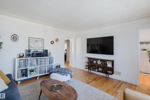 This living area features polished hardwood floors and white walls, creating a bright atmosphere - 10643 66 Avenue, Edmonton, AB - Indoor Photo Showing Living Room