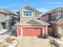 This property features a red facade with horizontal siding and a matching garage door with decorative paneling and windows - 4405 Crabapple Landing Landing, Edmonton, AB  - Outdoor 